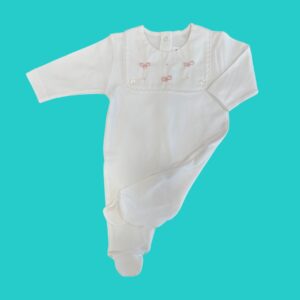 White baby onesie with pink bow embroidery and lace trim on a teal background